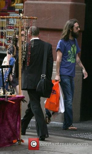 Chris Robinson of the Black Crowes walking in SoHo in sandals with his new girlfriend close behind him New York...