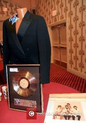 A John Lennon formal jacket and Capital Records gold record given to the Beatles for 1,000,000 records sold, and their...