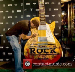 Woody Harrelson  signing the oversized guitar on the green carpet at the 'Hard Rock's 2007 Ambassadors of Rock Tour'...