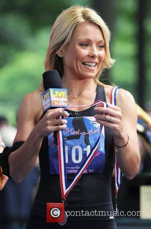 Kelly Ripa ABC's 'Live with Regis and Kelly' presents a medal to the winner of 'High-Heel-A-Thon' in Central Park...