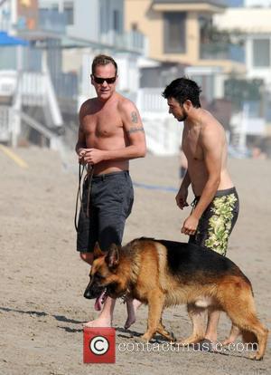 Kiefer Sutherland walks his dog with a friend on Malibu beach Los Angeles, California - 31.08.08