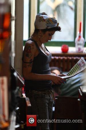 Amy Winehouse reads the paper whilst out with friends at a local pub. London, England - 11.11.08