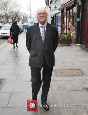 Sir Jimmy Savile walks in a suit in Golders Green London, England - 18.12.08