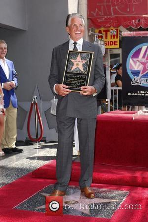 George Hamilton  poses with a plaque after being honored on the Hollywood Walk Of Fame. Hollywood, California - 12.08.09