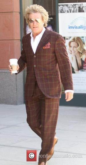 Rod Stewart  was spotted getting a Starbucks coffee in a brown suit in Beverly Hills Los Angeles, California, USA...