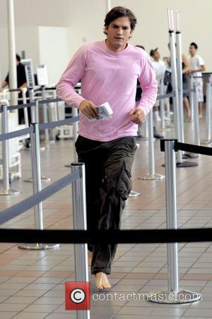 Ashton Kutcher running barefoot on the set of his new film 'Valentine's Day' shooting on location at LAX Los Angeles,...