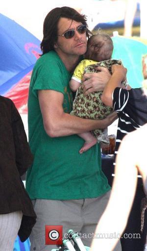 Jim Carrey holding his grandson Jackson Santan on Malibu Beach Malibu, California - 04.07.10