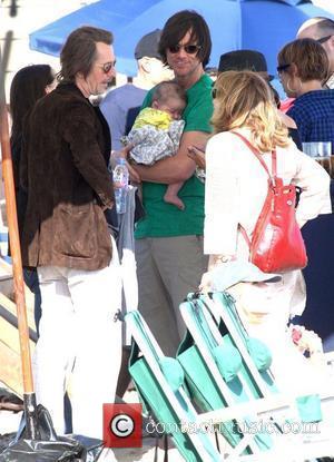 Jim Carrey holding his grandson Jackson Santana while talking to Gary Oldman on Malibu Beach Malibu, California - 04.07.10