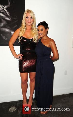 Brooke Hogan and Amaris Jones attend a portrait unveiling at the Women In Cages exhibit at Cafeina Lounge Miami, Florida...