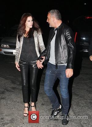 Christian Audigier takes his girlfriend Nathalie Sorensen for a celebratory dinner after a deal was finalised between the fashion designer's...
