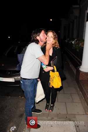 Dave Grohl plants a kiss on his wife Jordyn Blum's cheek as they arrive at their London hotel at 2am...