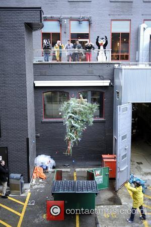 John Cho and Kal Penn  tossing a Christmas tree into a dumpster during their appearance on New.Music.Live to promote...