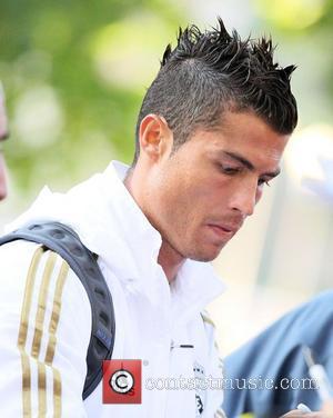 Real Madrid forward Cristiano Ronaldo signs autographs for fans as he leaves a training session with the rest of his...