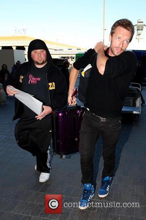 Chris Martin Coldplay frontman Chris Martin in good spirits as he arrives at LAX airport. Martin stopped and signed an...