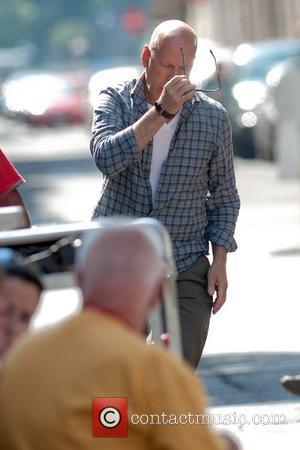 Bruce Willis puts on his sunglasses as he arrives on the film set for 'A Good Day to Die Hard'...