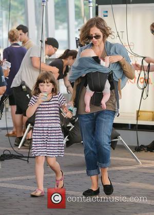 Maggie Gyllenhaal carries Gloria Ray Sarsgaard while daughter Ramona Sarsgaard walks alongside on the set of 'Very Good Girls.' New...