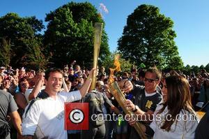 Melanie Chisholm and Chris Boardman exchange the Olympic flame as it passes through Liverpool Liverpool, England - 01.06.12
