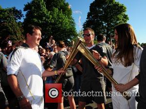 Melanie Chisholm and Chris Boardman exchange the Olympic flame as it passes through Liverpool Liverpool, England - 01.06.12