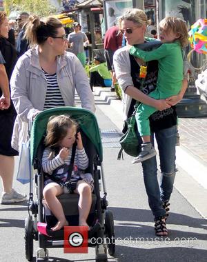 Kathleen Robertson and William Robert Cowles - Canadian actress Kathleen Robertson (R) carries her son as she talks with a...