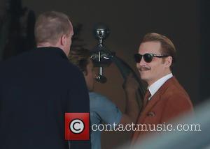 Johnny Depp - Johnny Depp filming on the set of 'Mortdecai' carrying a gold top cane and sporting a curly...