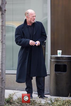 Ed Harris - An unshaven Ed Harris lights up a cigarette while taking a coffee break, resting his cup on...