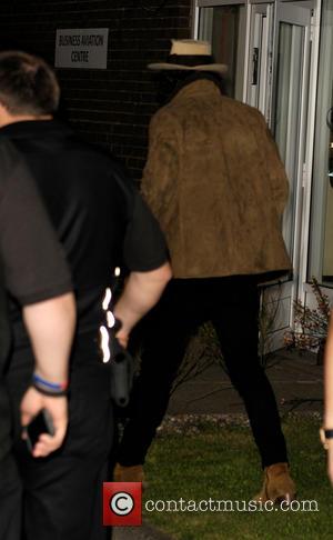 Harry Styles and One Direction - One Direction, surrounded by a heavy security team shielding the band from photographers, arrive...