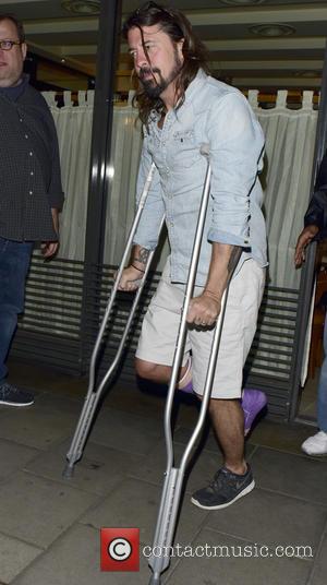 Dave Grohl and David Grohl - Dave Grohl leaving C London restaurant on his crutches with a purple cast on...
