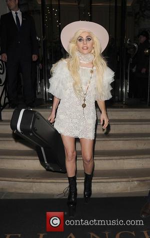 Lady Gaga leaving her hotel holding her guitar. Gaga was given a large painting on canvas by fan as she...